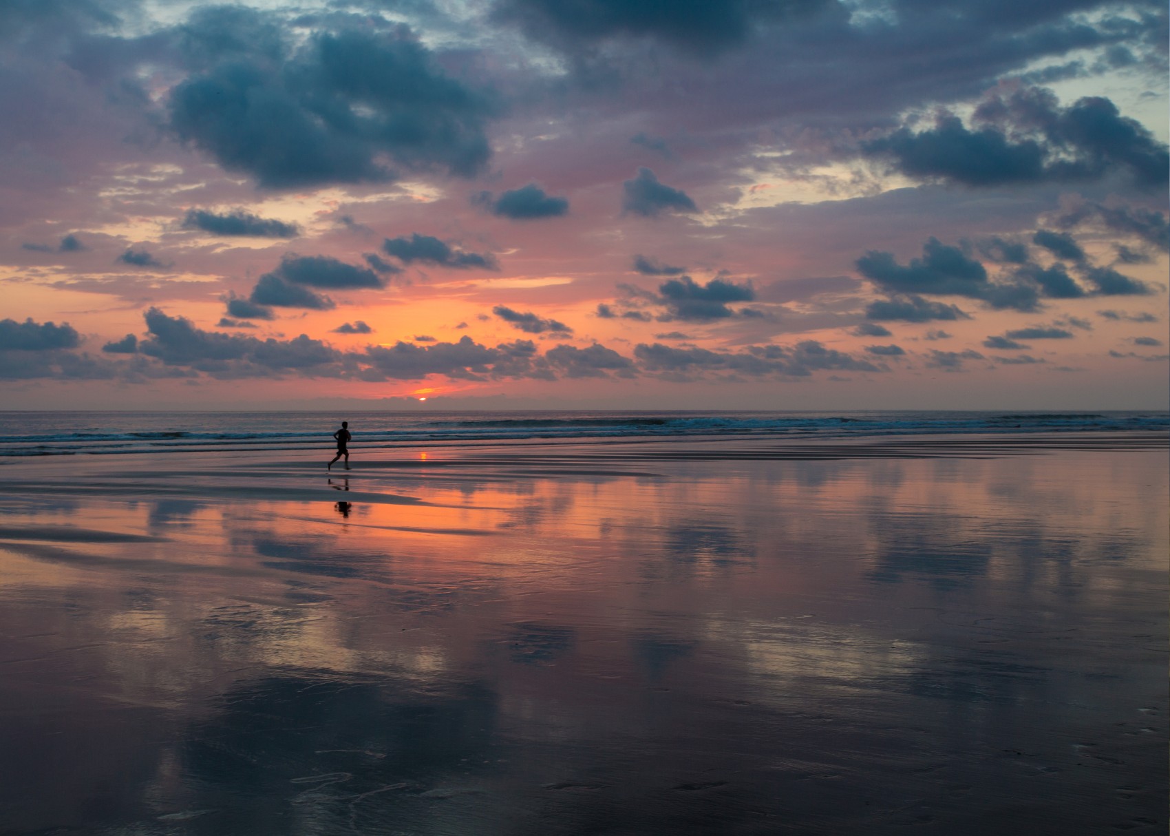 Matapalo Beach sunset a runner chases the endless waves along Matapalo Beach after sunset