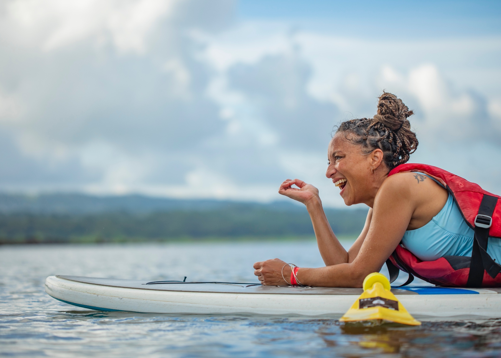 Costa Rica surfer a laughing woman takes time to rest between paddling in the Costa Rican surf